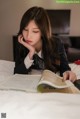 A woman laying on a bed reading a book.