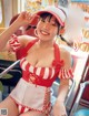 A woman in a red and white striped bathing suit and a red hat.