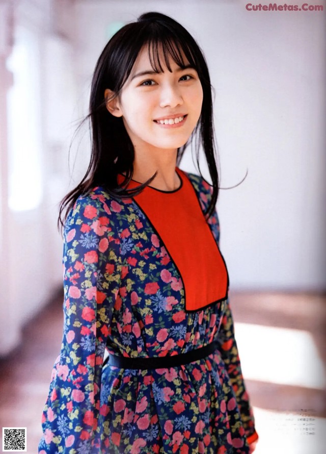 A woman in a blue and red dress posing for a picture.