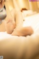 A woman is laying on a bed with her feet up.