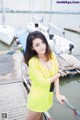 A woman in a yellow dress standing on a dock.