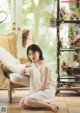 A woman sitting on the floor in front of a couch.